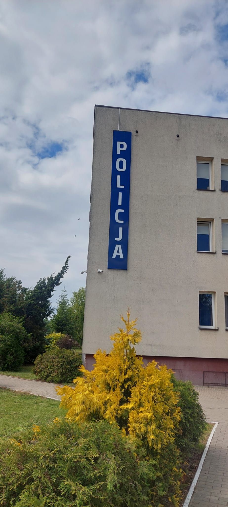 Budynek policji z niebieskim szyldem