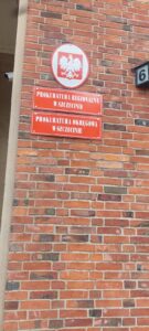 Tablice Prokuratur w Szczecinie na ceglanej ścianie.