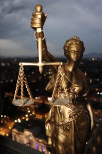 Złota figura Temidy z wagą i mieczem.